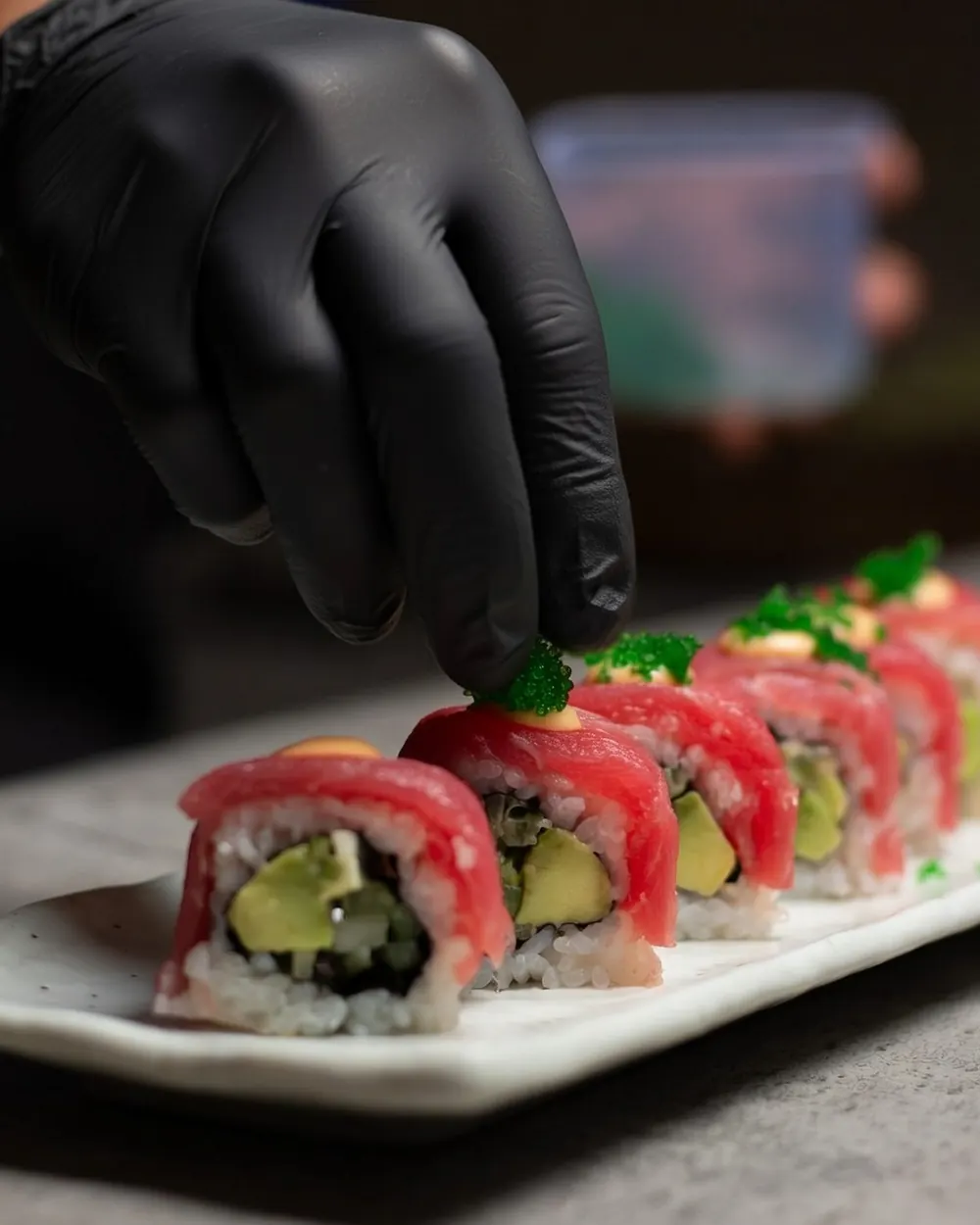 A chef finishing a tuna roll by hand at ENSO Japanese Fusion & Bar, Canggu